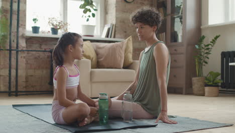 mother and daughter meditating together at home