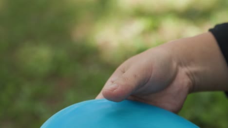 Close-up-shot-of-man-throwing-blue-disc-golf