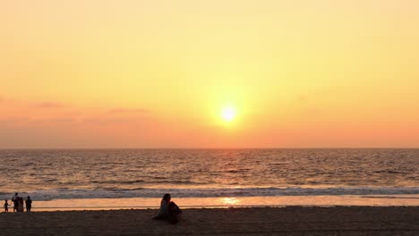 Ein-Paar-Legte-Sich-Auf-Den-Sand-Und-Beobachtete,-Wie-Die-Sonne-über-Den-Ozeanhorizont-Ging