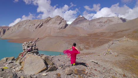 el paisaje del lago tilicho de manang, nepal, revela a una mujer disfrutando de un vestido rosado, montaña, clima frío, el lago de mayor altitud del mundo y el circuito de montaña filmado por drones en 4k.