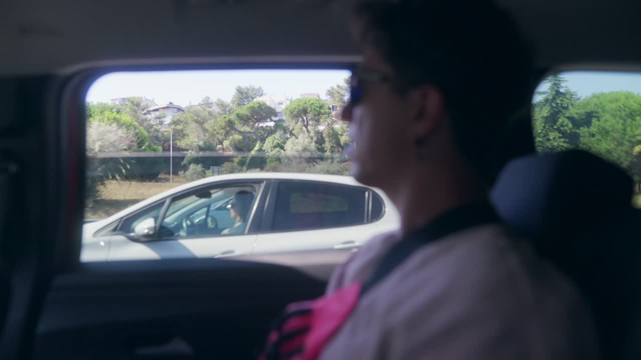 Person looking out of a car window during a road trip