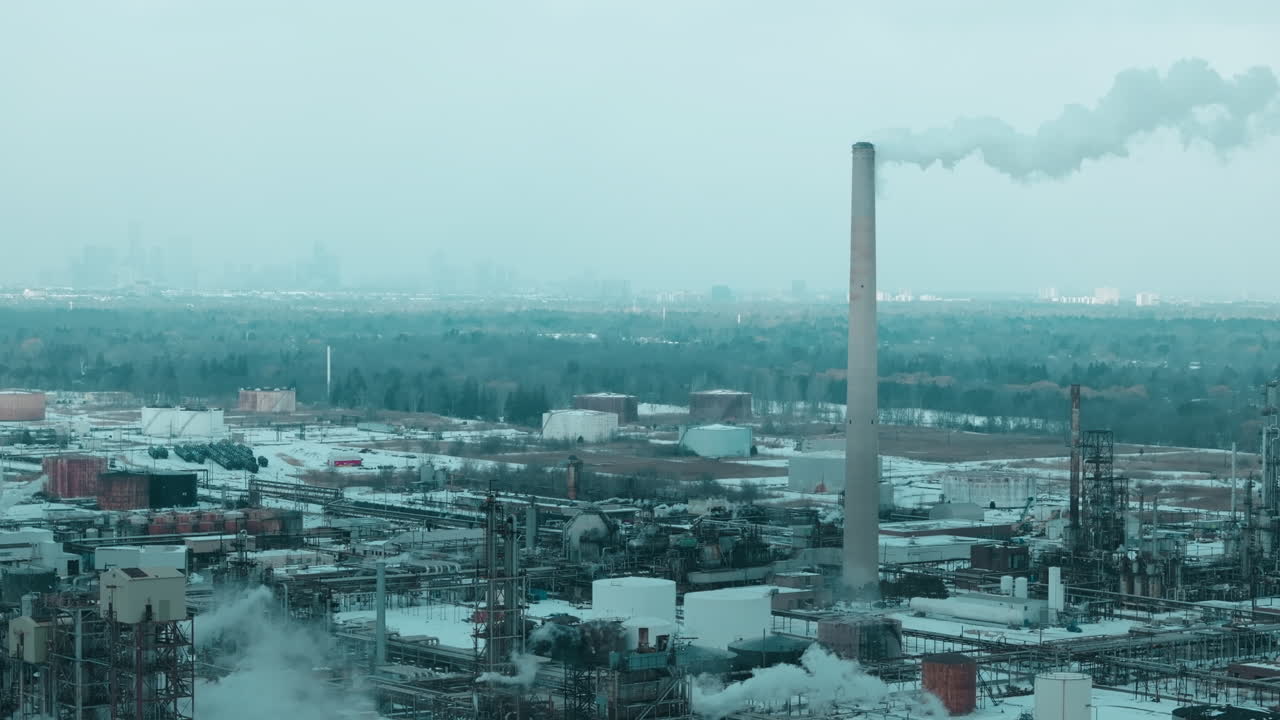 Industrial smokestacks emit pollution in Canada, symbolizing climate change