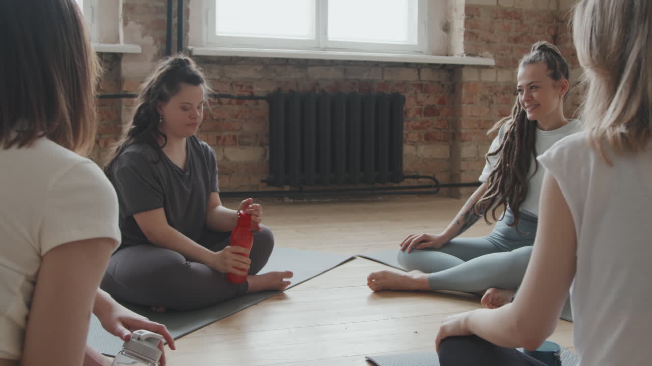 Young Women Resting After Indoor Group Yoga Class