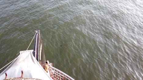 midshot of traditional keralan houseboat and waves at alappuzha, kerala, india