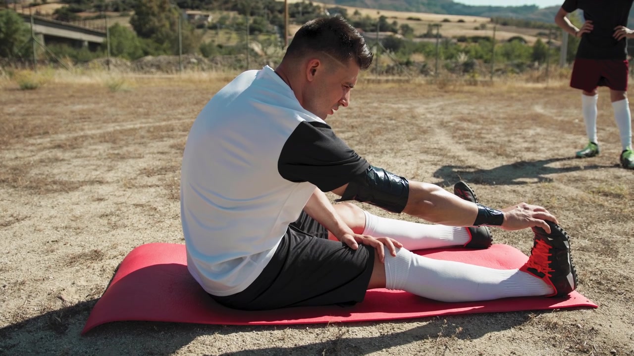 Tired Soccer Player Stretching After The Game