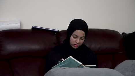 relaxed individual lounging on a cozy sofa in an indoor environment, jotting down notes in a notepad book, encapsulating the concept of creativity and productivity