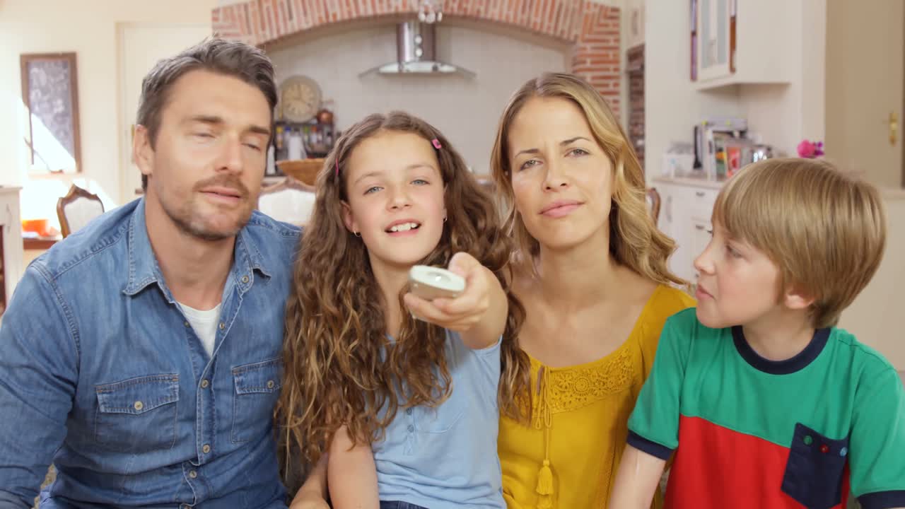 소파에서 리모컨을 사용하는 행복한 가족