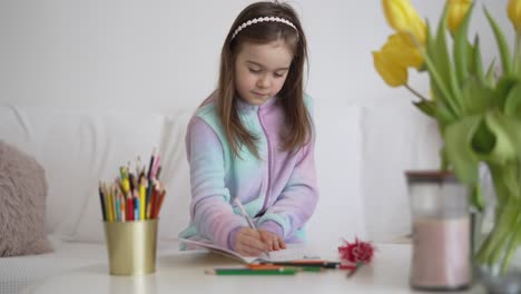 la niña coloreando en casa