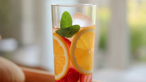 refreshing fruit infused drink with orange, strawberry, and mint