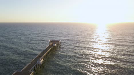 san clemente pier on california coast at sunset, aerial arc shot