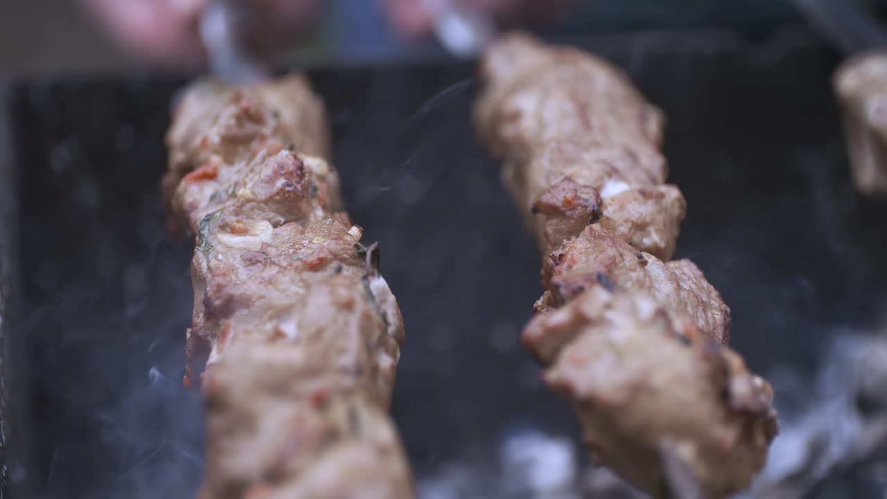 Dois pedaços de carne sendo grelhados em uma churrasqueira preta. A carne está marrom e tem um sabor defumado.