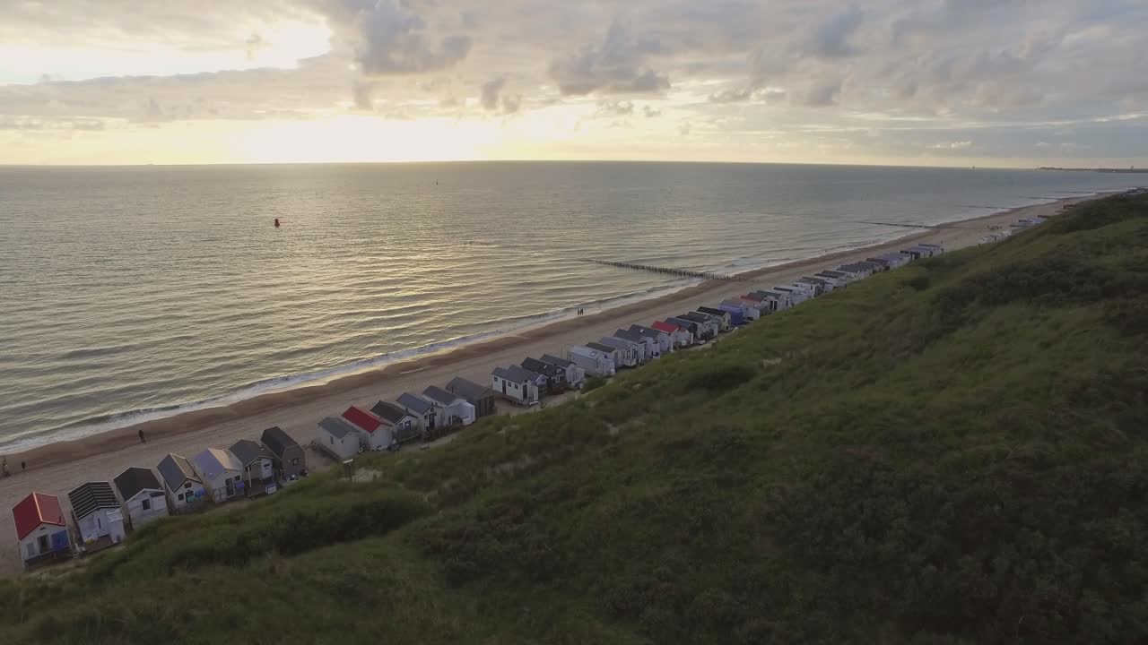 Beach huts on the coast under a cloudy sky