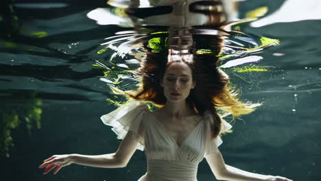 ethereal woman floating underwater