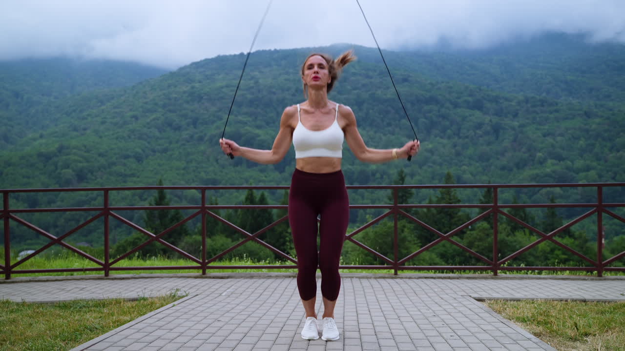 mujer saltando la cuerda en la vista de la montaña