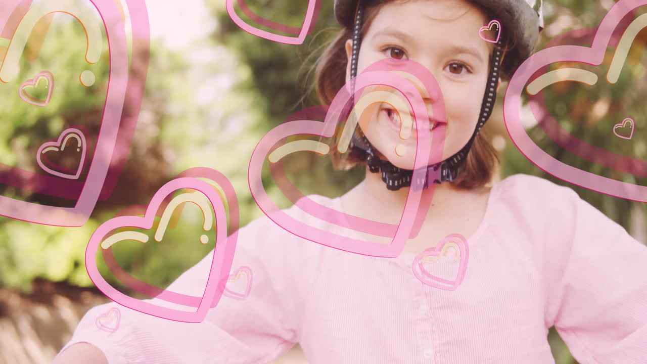 Wearing helmet, smiling child with animation hearts in outdoor background