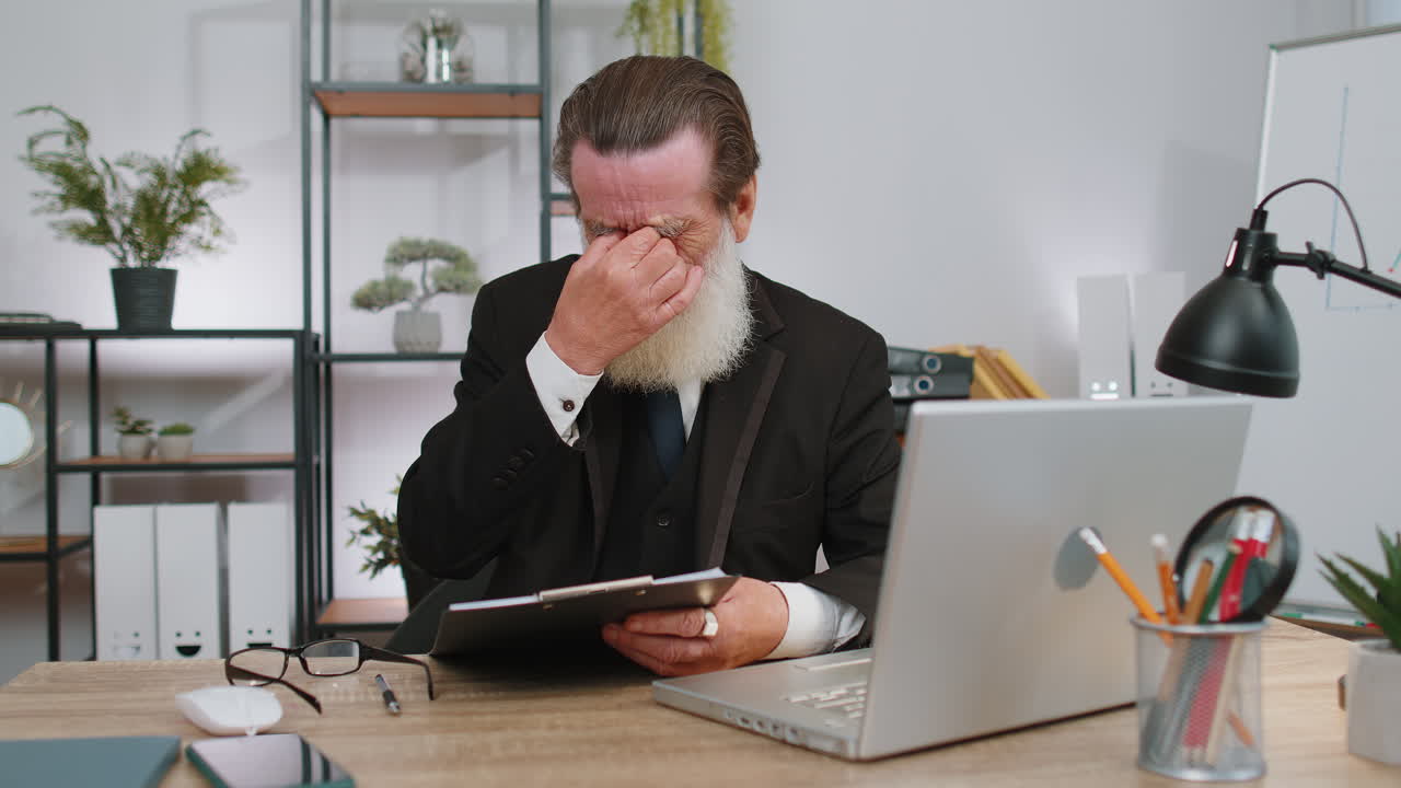 Stressed senior man feeling worried about problem analyzing information, bankruptcy, money debt