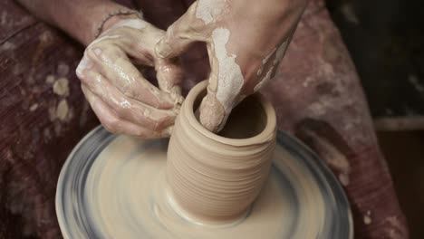 the potter makes a jug of clay. ceramist. a man makes a vase on a potter's wheel