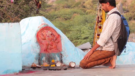 Young-Indian-Hindu-student-praying-to-the-god-in-fear-of-exams,-results-or-interview-at-outdoor-temple-