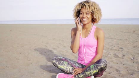 mujer joven sonriente charlando en un teléfono móvil