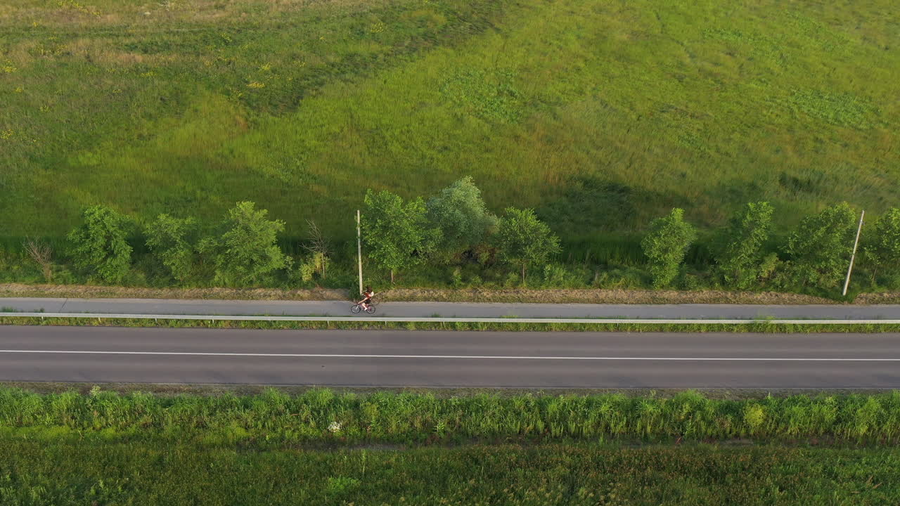 시골 풍경 을 통해 길 을 따라 자전거 를 타고 있는 사람 들 의 공중 촬영