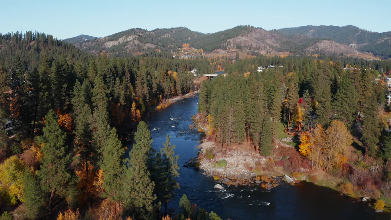 vista aérea de un pequeño pueblo rural a orillas del rápido río azul rodeado de bosque en washington, estados unidos