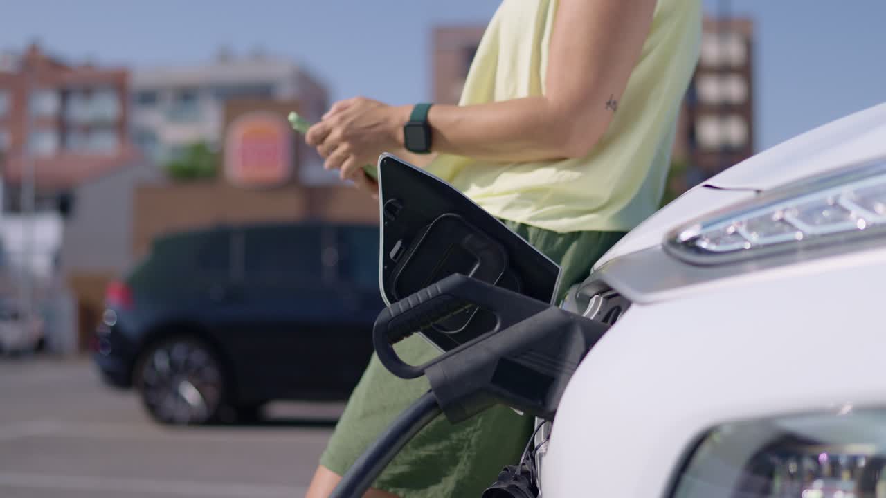 Woman charging her electric vehicle