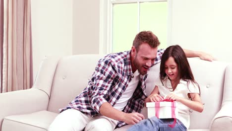 smiling father offering gift to his daughter