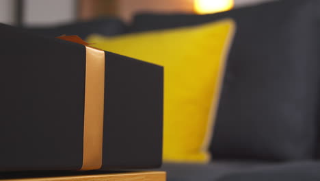 close up of gift wrapped present with bow on table in lounge at home 5