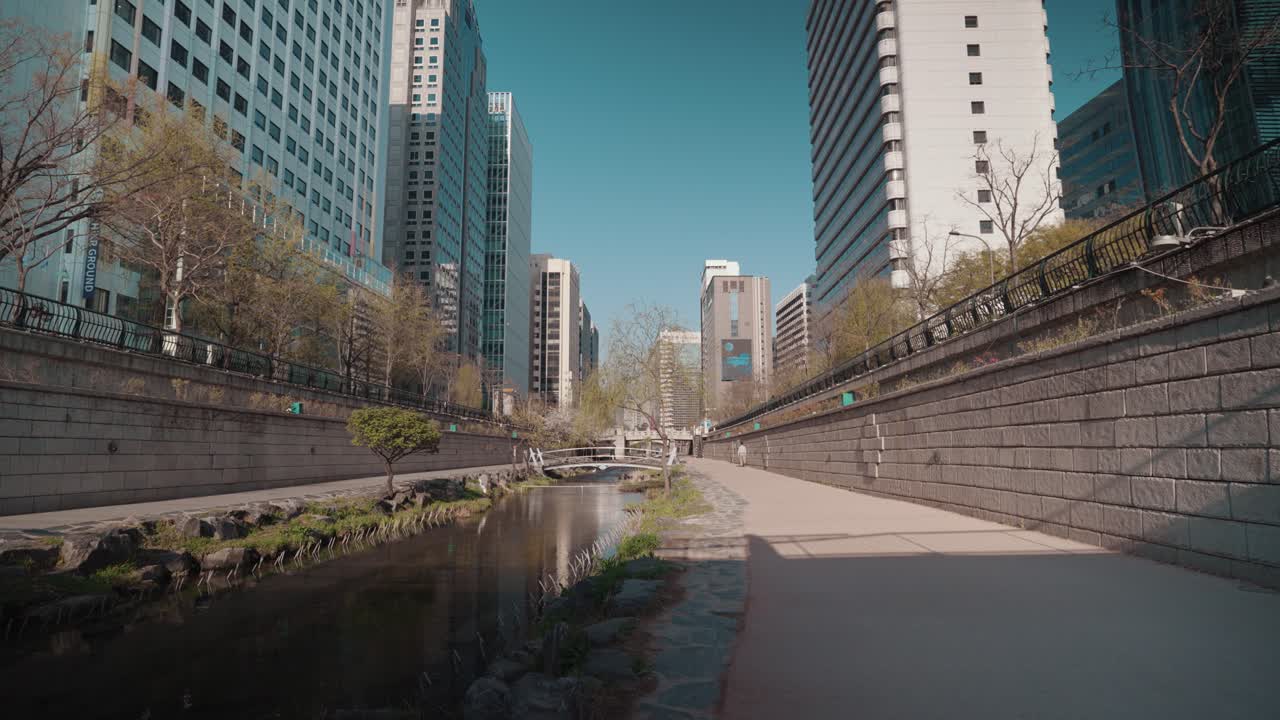 Passeggiata fluviale urbana con moderni edifici cittadini e cielo sereno