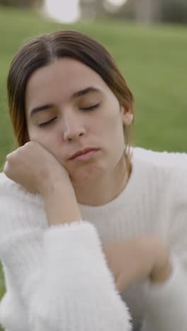 young woman resting chin on hand with a bored expression