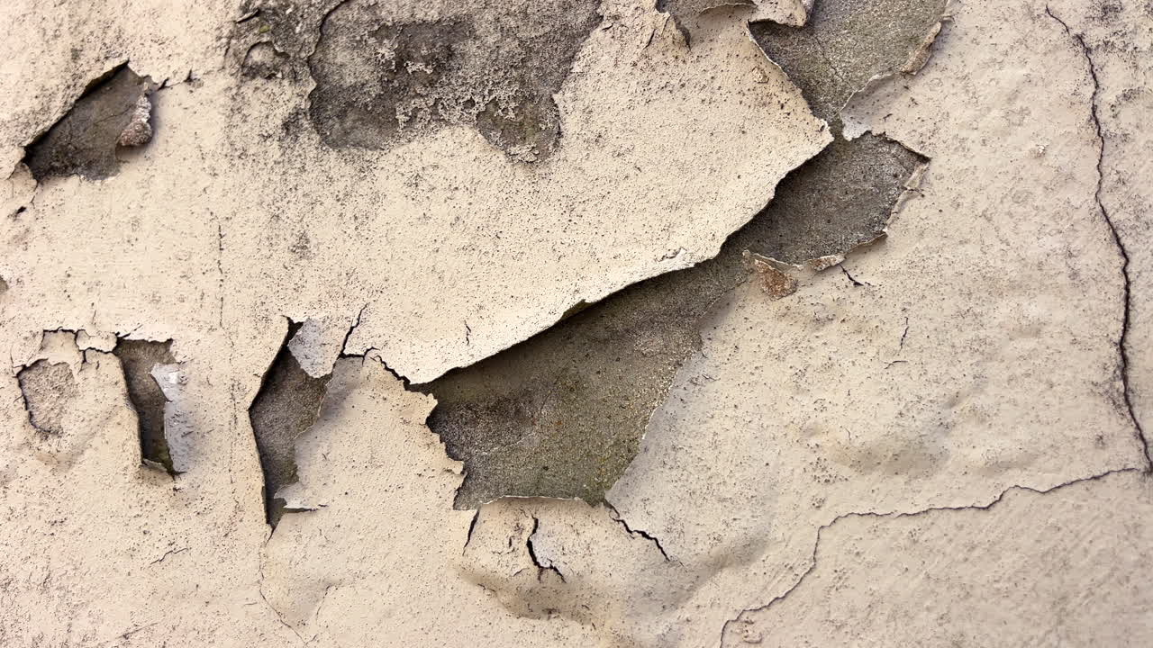 Close up of peeling paint on cement render wall, weathered facade texture background