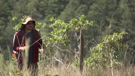 man in the forest watering new trees, pesticide or fertilizer, using a backpack sprayer