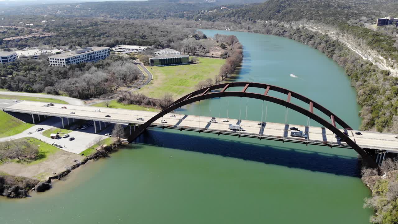 Aerial Austin Pennybacker Bridge - with full bridge expanse in frame including boat landing, moving towards the bridge until the length nearly fills the edges of the frame.