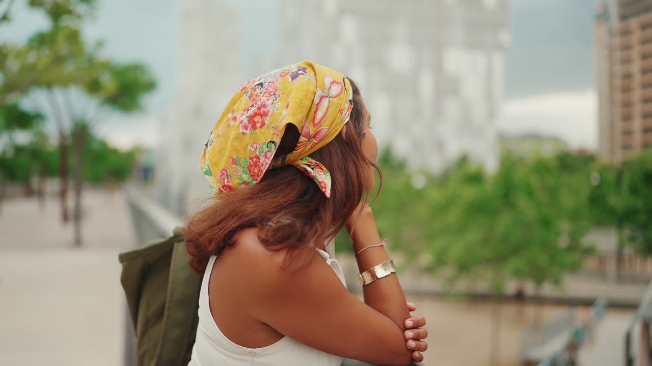 Donna con foulard floreale che guarda la città