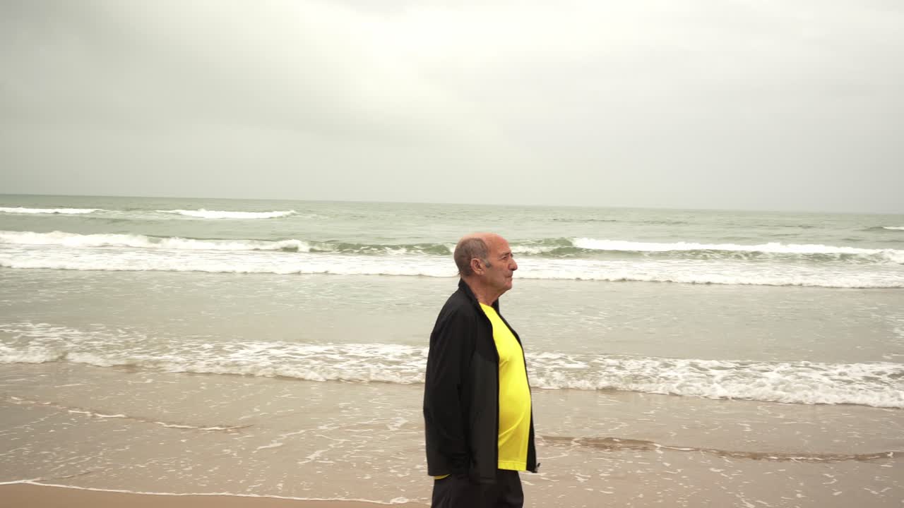 atleta masculino senior caminando cerca del mar