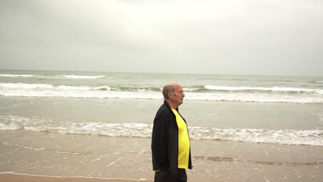 senior male athlete walking near sea