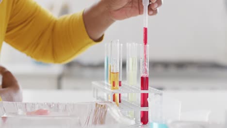 de las manos de una abuela afroamericana haciendo un experimento de química con su nieta, copia el espacio