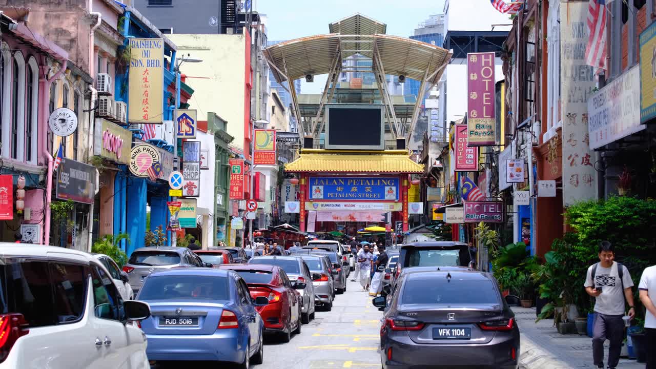 Street view of Jalan Petaling with busy traffic and people in Chinatown, capital city of Kuala Lumpur, Malaysia