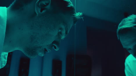 man looking at his reflection, sad and disappointed