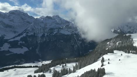 Drone-shot-of-a-picturesque-misty-highlands-of-the-alpine-mountains-in-Engelberg,-Brunni,-Bahnen-in-Switzerland