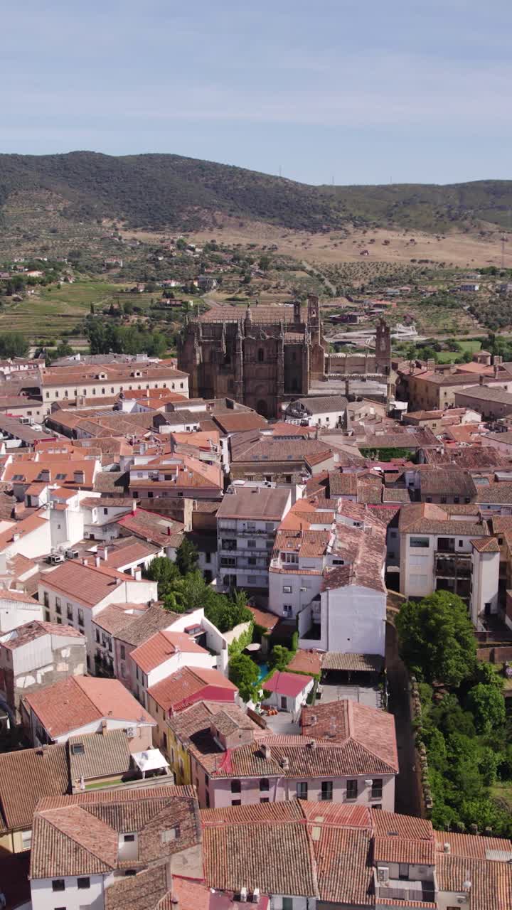 Volando sobre los históricos tejados de Plasencia con la catedral elevándose sobre el paisaje urbano romano y medieval. Aérea vertical