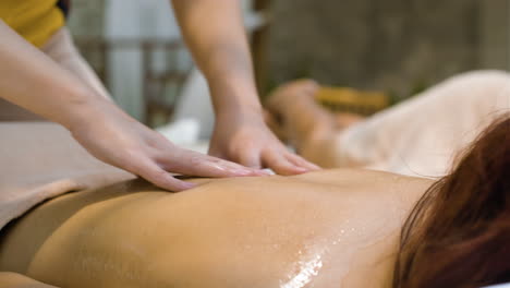 masseuse giving back massage to woman