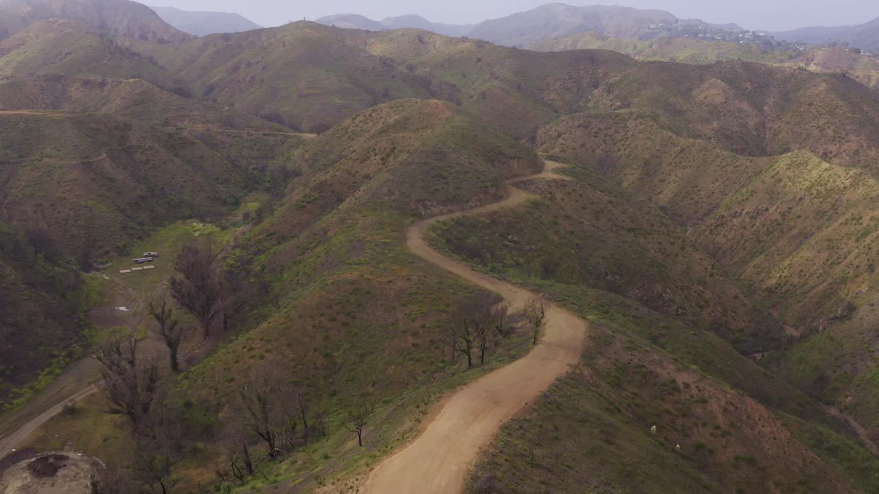 Low aerial shot flying over the Inspiration Trail up the mountain in Will Rogers State Historic Park after the wildfires in Los Angeles, California. 4K