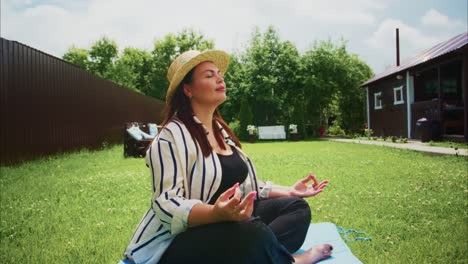 woman practicing meditation outdoors in a serene garden with lush greenery and bright sky