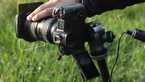 Photographer-sets-the-shot-on-a-camera-mounted-on-a-tripod-and-selects-the-focus,-takes-the-picture-with-an-intervalometer