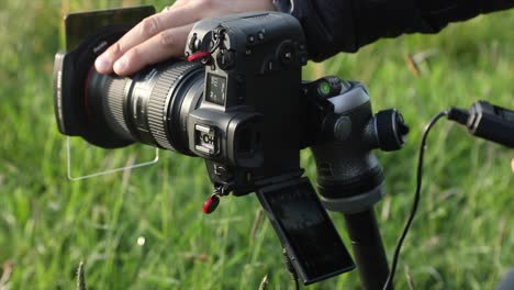 El-Fotógrafo-Coloca-La-Fotografía-En-Una-Cámara-Montada-Sobre-Un-Trípode-Y-Selecciona-El-Enfoque,-Toma-La-Fotografía-Con-Un-Intervaloómetro.