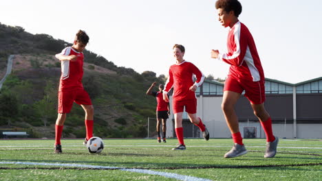 group of male high school students with coach playing in soccer team