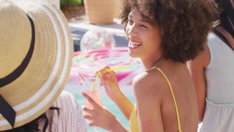 felices amigas diversas hablando y sonriendo en la fiesta de la piscina