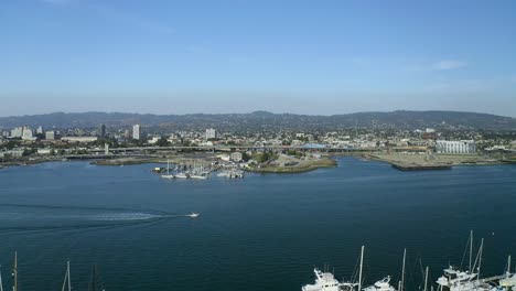 Ein-Langsamer-Zug-Zurück-über-Die-Bucht,-Segelboote-Und-Den-Stadthintergrund