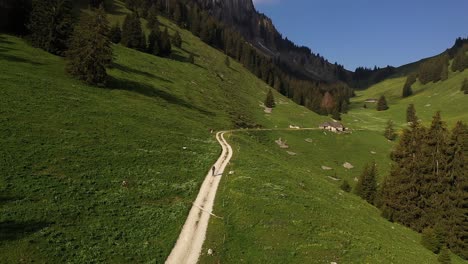 Luftaufnahme,-Drohnenaufnahme,-Trekking-Allein-Auf-Dem-Bergtalweg-Zu-Einem-Haus